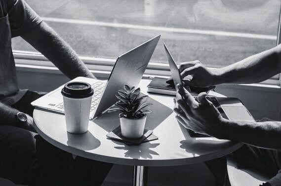 to personer jobber på laptop på kafé